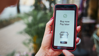 Das Bild zeigt ein Handy auf dessen Display "Buy now, pay later" steht; Copyright Panthermedia