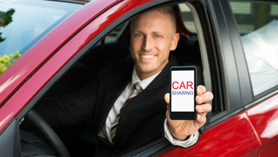 Mann hält Handy mit Carsharing-App aus dem Autofenster; Copyright Panthermedia