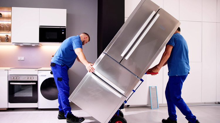 Zwei Arbeiter stellen großes Kühlgerät auf, Copyright Panthermedia