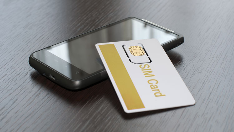 Handy liegt auf einem Tisch, daneben eine SIM-Karte; Copyright Panthermedia